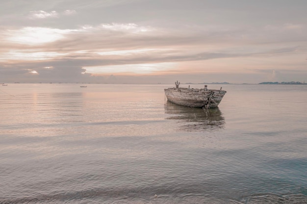 Barco en el mar contra el cielo durante la puesta del sol