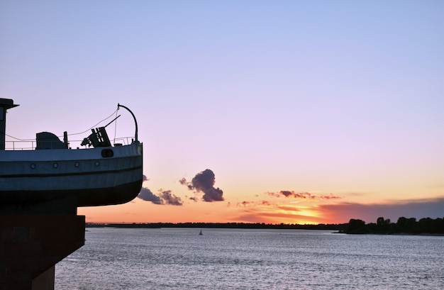 barco en medio de la puesta de sol en el río