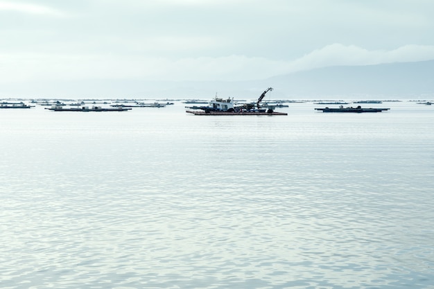 Barco de mejillones trabajando cerca de camas de mejillón en el mar