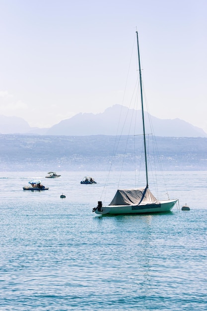 Barco a motor en el lago de Ginebra en Lausana, Suiza. Alpes en el fondo