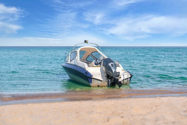 Un barco de motor de mar estacionado en la laguna cerca de la costa, viajes vacaciones de verano