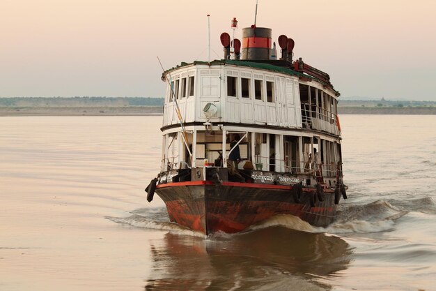 Barco na água ao nascer do sol do rio Irrawaddy perto de Mandalay, Myanmar