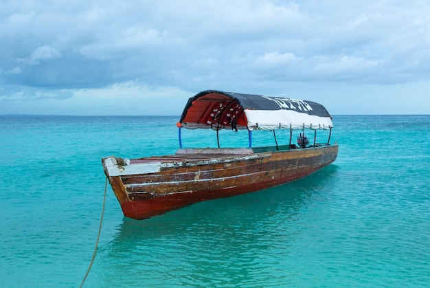 Barco na praia na ilha de Zanzibar com água turquesa deslumbrante