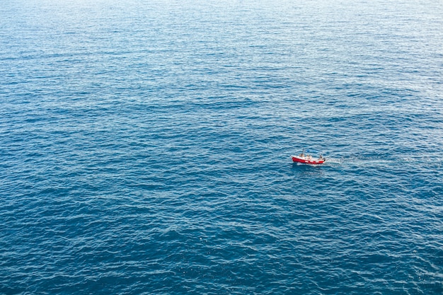 Barco na vista aérea da superfície azul do mar.