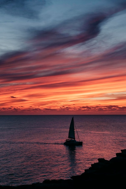 Un barco navega en el mar al atardecer.