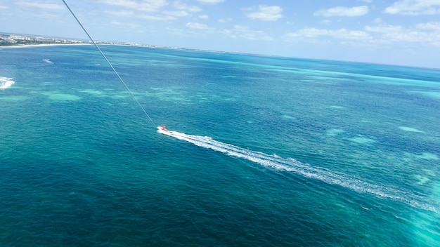 Un barco navega en el océano con vistas a la isla caribeña al fondo.