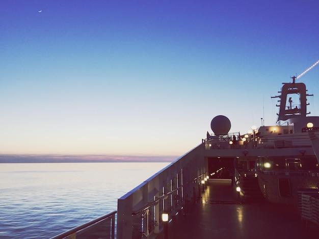 Foto un barco navegando en el mar contra un cielo despejado durante la puesta de sol