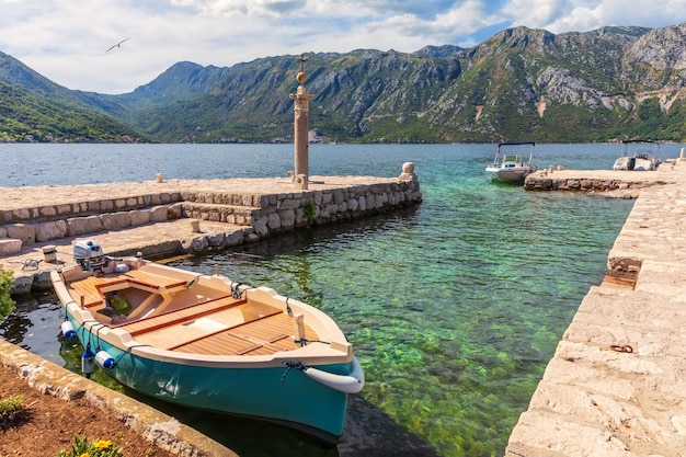 Barco no cais de Nossa Senhora na ilha rochosa perto de Perast Montenegro