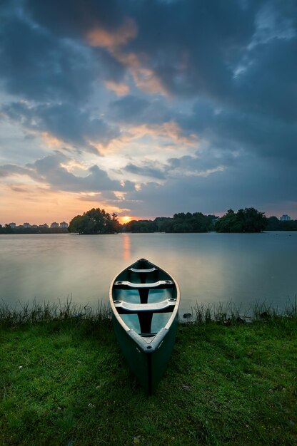 Barco no lago contra o céu durante o pôr do sol