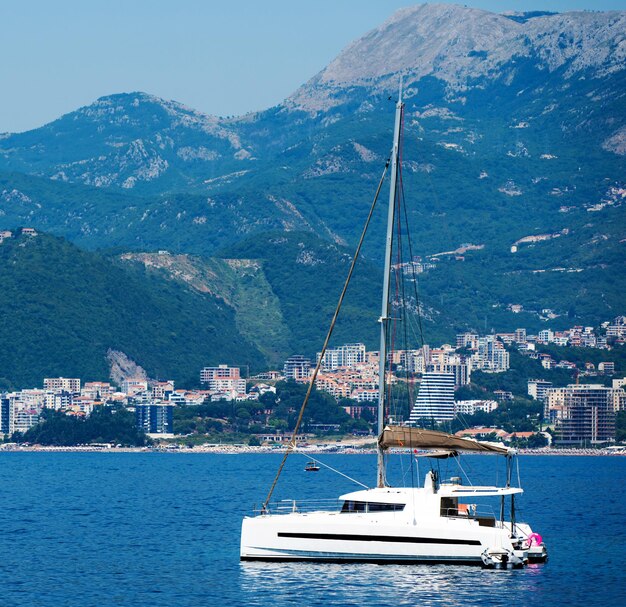 Barco no mar Adriático com vista antiga Budva em Montenegro. Cidade antiga com montanhas de iate no Mediterrâneo