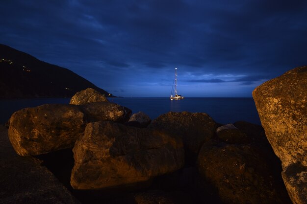 Foto barco no mar com uma moldura de pedras