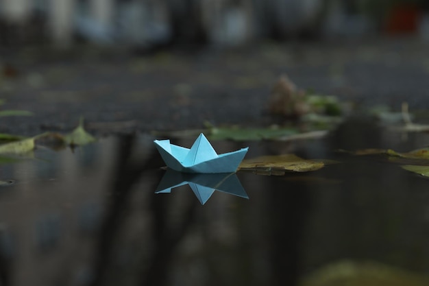 Barco de papel en un charco al aire libre cuando llueve