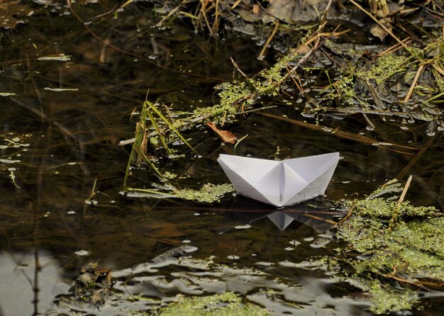 Un barco de papel flota en un pequeño río región de Moscú Rusia