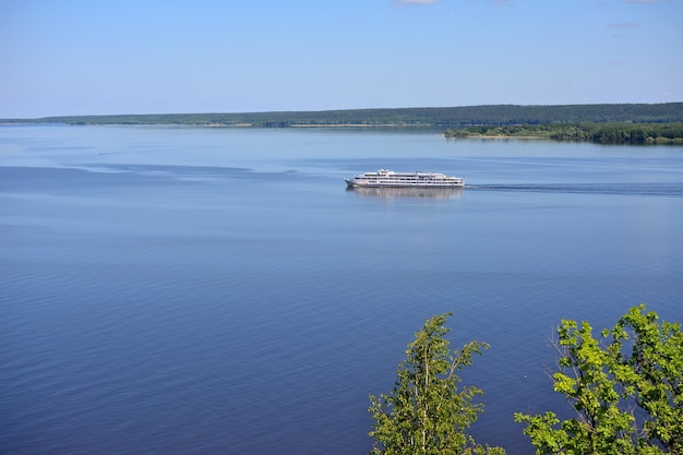 barco de pasajeros nadando en el río Volga con isla y cielo azul en el horizonte