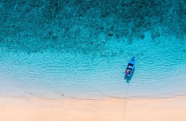 Barco perto da praia Fundo de água azul da vista superior Paisagem marítima de verão do ar Paisagem aérea Imagem de viagem