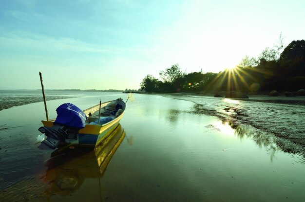 Barco perto da praia quando o sol se põe