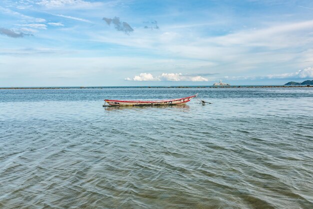 Barco de pesca abandonado en medio del mar en una isla tropical