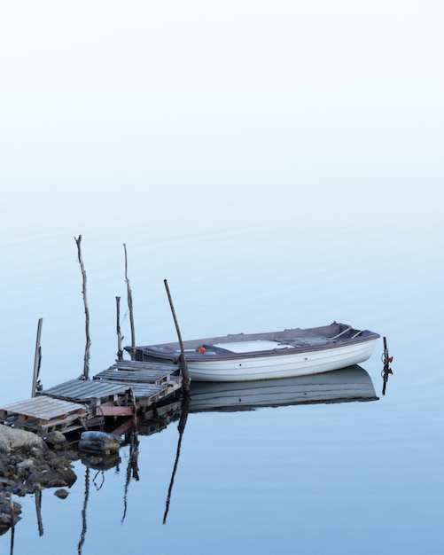 Foto barco de pesca amarrado en el lago contra un cielo despejado