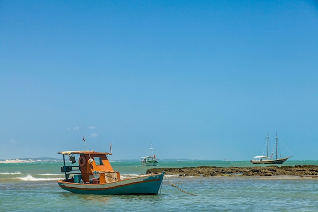 barco de pesca anclado cerca de un arrecife.