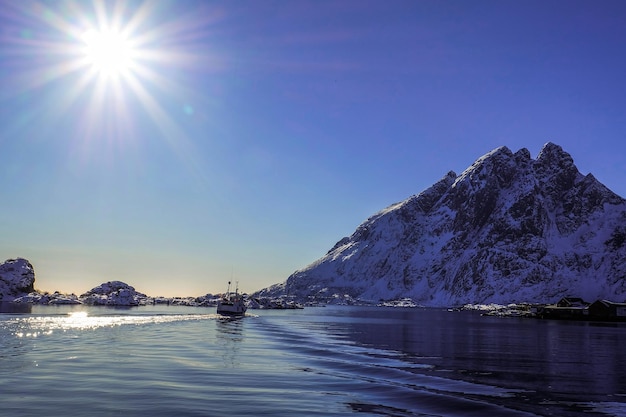 El barco de pesca flotó en el lago durante el sol de las islas Lofoten, marzo de 2018