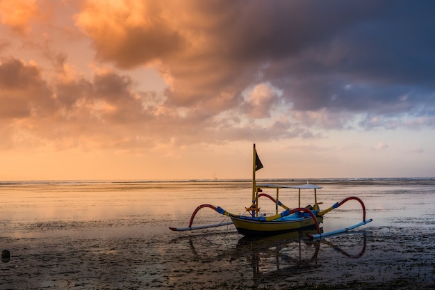 barco de pesca Jukung durante el amanecer en la playa de Sanur