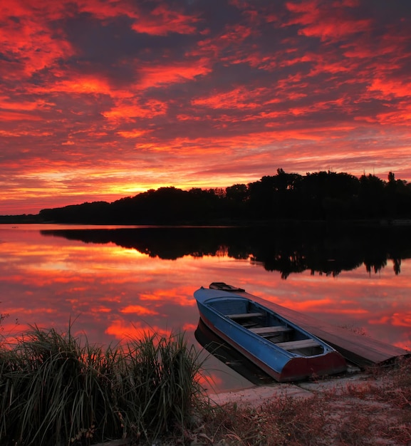 Barco de pesca en el lago al atardecer Paisaje de verano