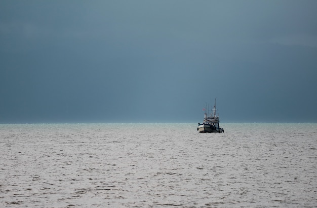 Barco de pesca navegando bajo el cielo tormentoso, Golfo de Tailandia