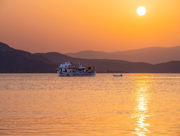 Barco de pesca y pesca al atardecer en el Mar Egeo cerca de la isla de Evia en Grecia