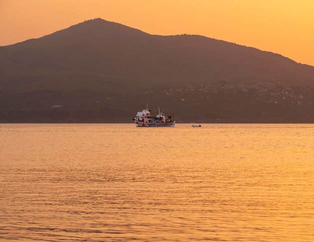 Barco de pesca y pesca al atardecer en el Mar Egeo cerca de la isla de Evia en Grecia