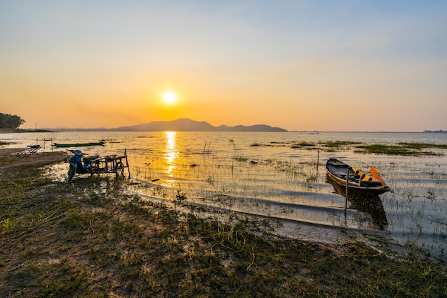 Barco de pesca con puesta de sol en el embalse de Bang Phra