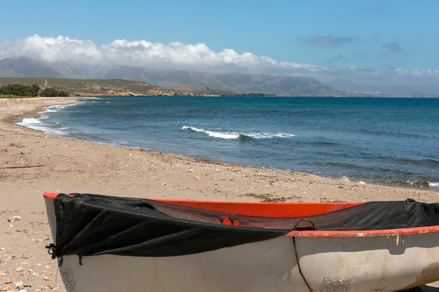 barco de pesca situado en la arena junto a la orilla con vistas al resto de la playa en calnegre