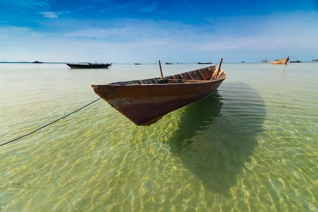 Barco de pesca tradicional en el mar con agua clara.