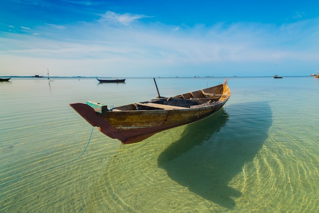 Barco de pesca tradicional en el mar con agua clara.