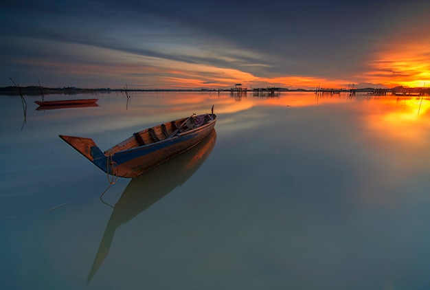 Barco de pesca tradicional en un pueblo de pescadores al atardecer en la isla de Batam