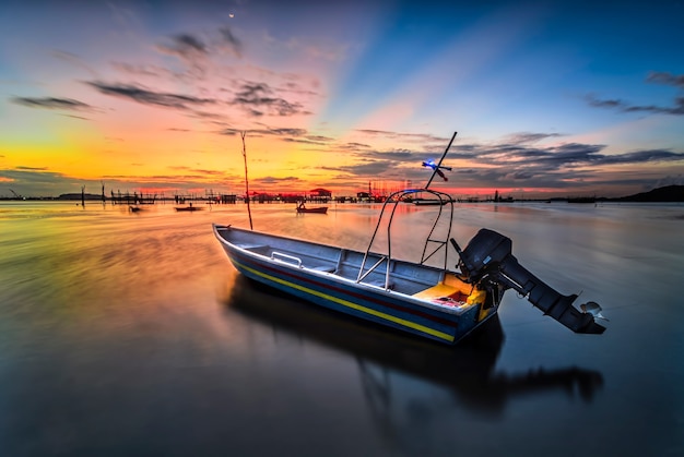 Barco de pesca tradicional en el pueblo de pescadores en una hermosa puesta de sol