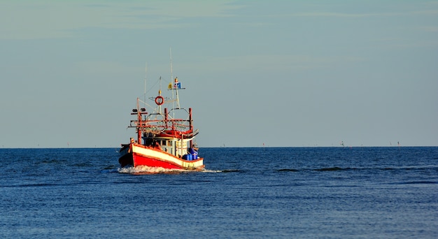 Un barco pescador en un fondo de cielo azul del mar