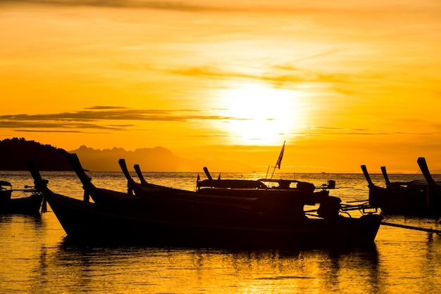 barco de pescadores de silueta en el fondo de la puesta del sol