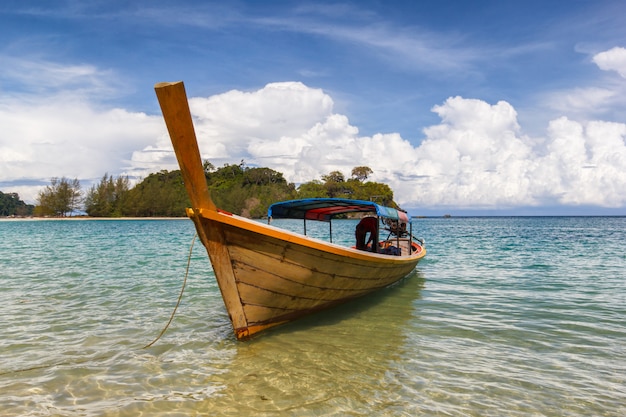 Barco pesquero flotando en el mar azul con playa de arena blanca y hermoso cielo azul en la isla de Kangkao