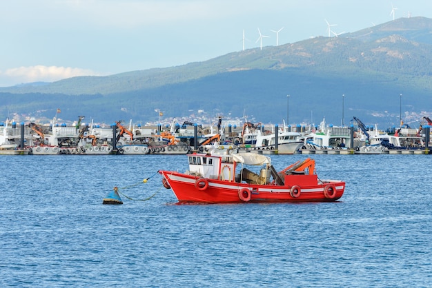 Barco pesquero de madera roja amarrado en el puerto pesquero