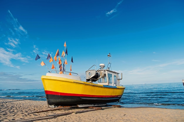 Barco en la playa de arena en Gdansk, Polonia. Barco pequeño en la orilla del mar en el cielo azul. Transporte por barco y agua. Vacaciones de verano y viajes por mar. Pasión por los viajes con aventura y descubrimiento