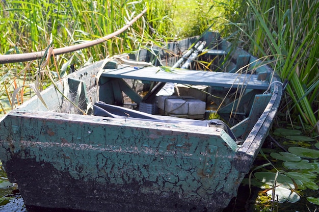 Barco quebrado dilapidado gasto de madeira velho para nadar nas margens do mar do lago do rio