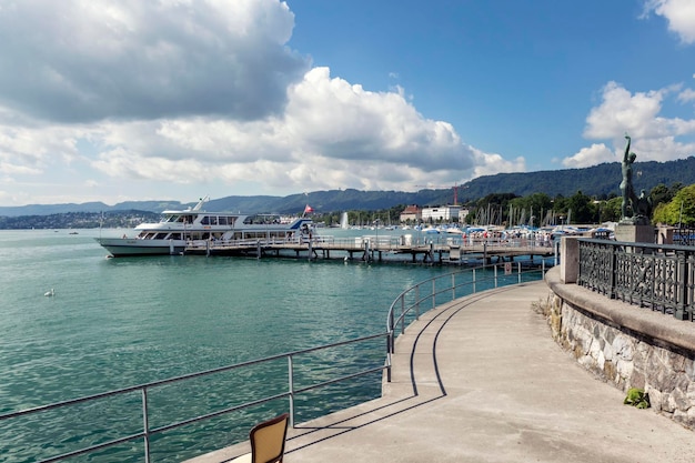 Barco de recreo con gente descansando en el muelle Paseos acuáticos y recreación activa Zurich Suiza 20160729