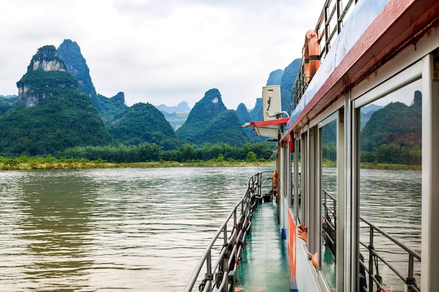 Barco de recreo en el río Li conocido como río Lijiang. y picos kársticos en Xingping Town