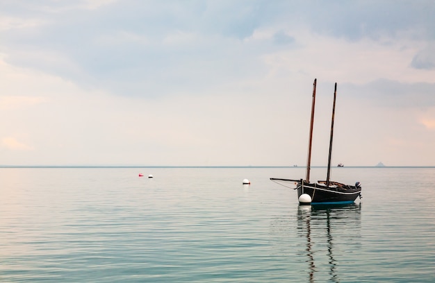 Barco reflejándose en el mar en calma en Cancale, Bretaña, Francia