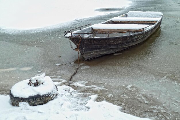 Barco en el río congelado cubierto de nieve