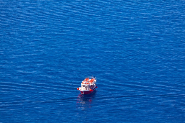 Un barco rodeado de botes de agua en el mar azul