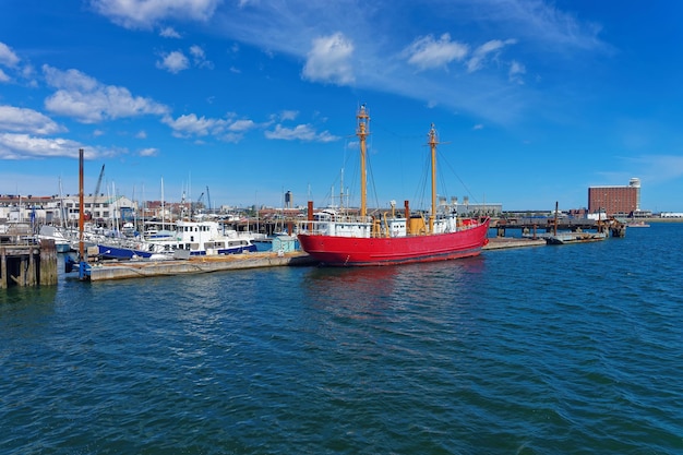 Barco rojo amarrado cerca del muelle en el Puerto de Boston en la ciudad de Boston, Estados Unidos. El puerto es uno de los principales puertos marítimos de la costa este de EE. UU. y del estado de Massachusetts.