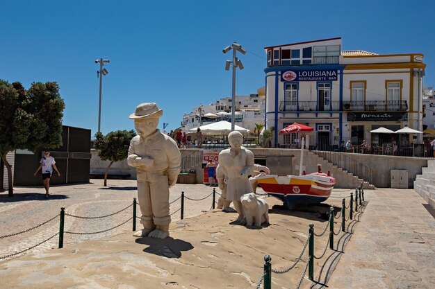 Barco rojo diciendo Albufeira y pescador obras de arte ciudad monumento símbolo Portugal