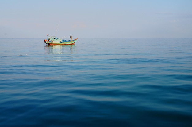 Un barco solitario en el mar tranquilo contra un cielo despejado