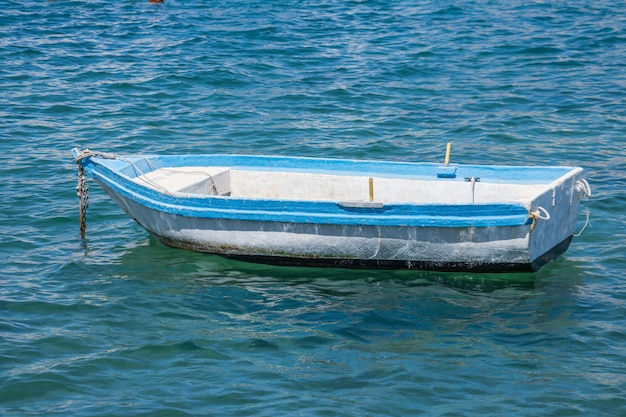 Un barco solitario en el puerto amarrado en el agua.